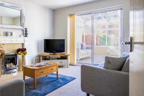 a living room with a couch and a tv at Fair View - Off Street Parking and Garden in Shrewsbury