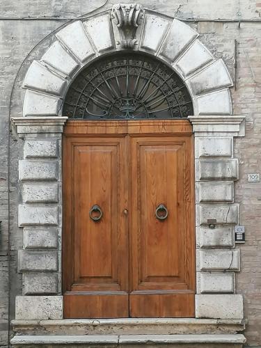 una porta in legno su un edificio con arco di Palazzo Trevisani a Porto San Giorgio