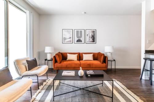 a living room with an orange couch and a table at 2BD 2BTH Condo 10 Min Walk to Santa Monica Beach in Los Angeles