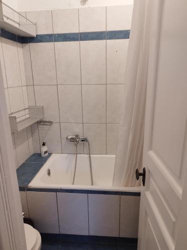 a bathroom with a bath tub and a toilet at Комната pilika 4room with shared bath in Athens