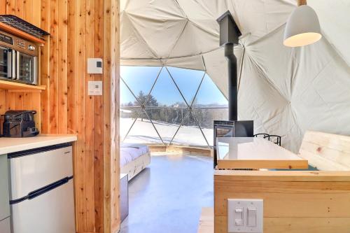 a kitchen with a tent with a large window at mi-clos - luxury pods with private jacuzzis in Orford
