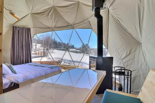 a bedroom with a bed in a tent at mi-clos - luxury pods with private jacuzzis in Orford