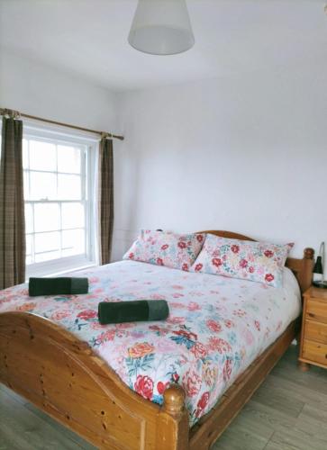 a bedroom with a bed with two pillows and a window at Bryn Awel in Aberystwyth