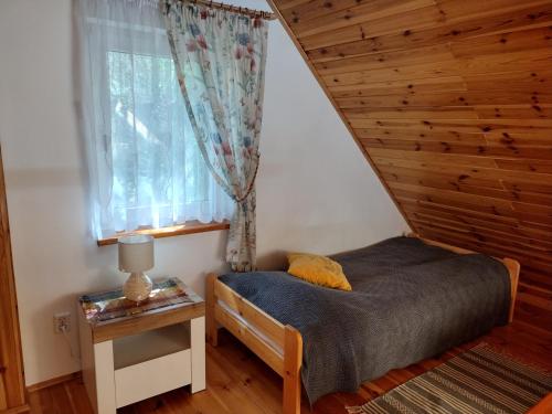 Habitación pequeña con cama y ventana en Fajny Domek w Nartach, en Narty