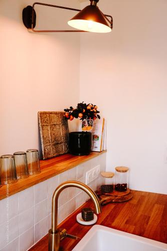 une cuisine avec un évier et un plan de travail dans l'établissement Le Beffroi : appartement cosy en cœur de ville, à Armentières