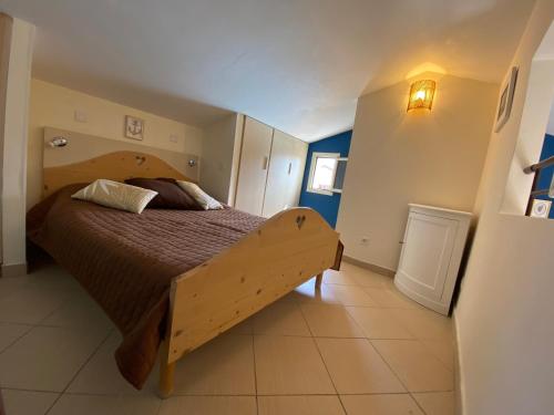 a bedroom with a large bed with a wooden frame at Lozari Beach in Belgodère