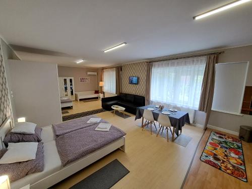 ein Wohnzimmer mit einem Sofa und einem Tisch in der Unterkunft Árkád Apartmanház Szeged in Szeged