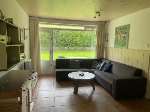 uma sala de estar com um sofá e uma mesa em Vakantiehuisje Martina 17 em Vlissingen