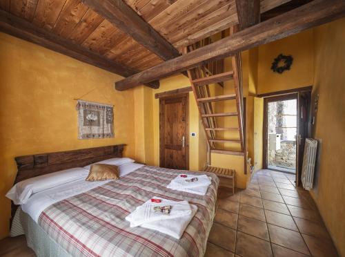 a bedroom with a bed with towels on it at Locanda Del Silenzio Residence in Macra