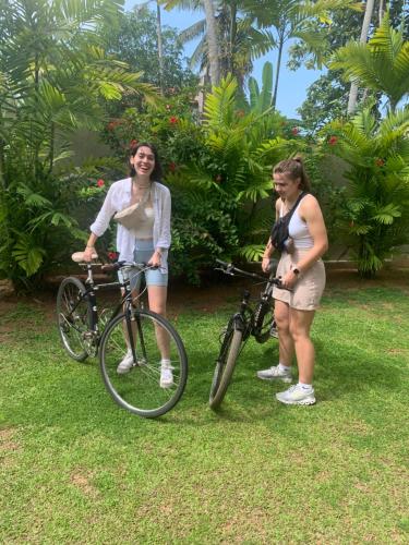 two women standing next to their bikes in the grass at Anveela in Beruwala