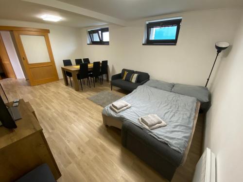 a bedroom with a bed and a living room with a table at Apartmány u Moravčíků in Bulhary