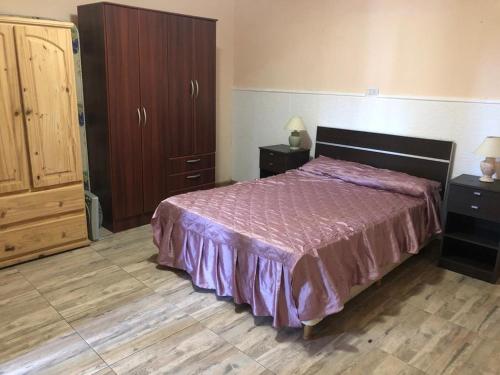 1 dormitorio con 1 cama con colcha púrpura en Sweet Home Casa Parque cerca del Polideportivo y Hospital Privado Comunidad en Mar del Plata