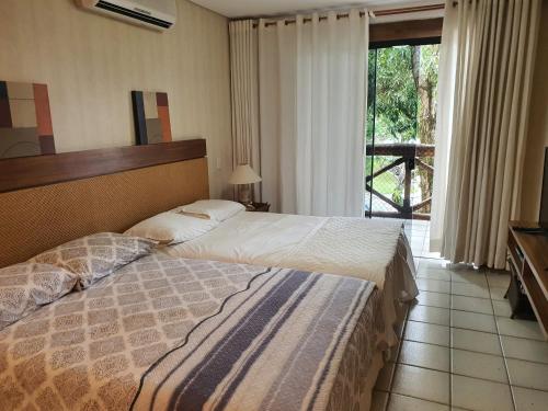 Habitación de hotel con cama y ventana en Flat TOP em Itaparica en Itaparica Town