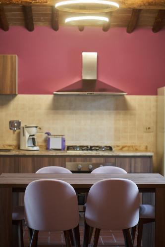 a kitchen with a wooden table with four chairs at Podere Sant'Antonio in Asciano