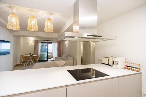 a kitchen with a white counter top and a living room at Gran piso en Puerto deportivo Marina Palamós IDEAL FAMILIAS in Palamós