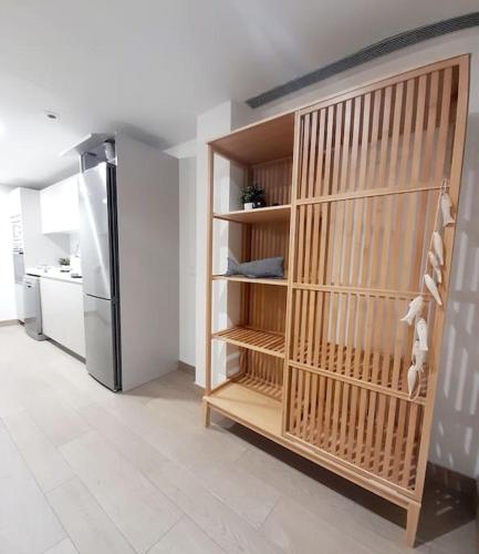 a kitchen with a refrigerator and a shelf in a room at Gran piso en Puerto deportivo Marina Palamós IDEAL FAMILIAS in Palamós