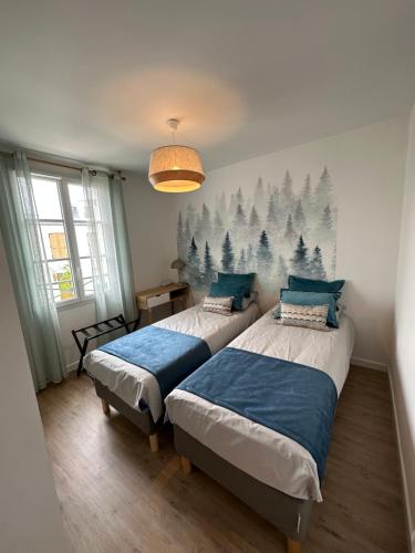 a bedroom with two beds and a mural of trees at Disneyland Paris, vallée village ,Paris , villa, garden , Syline Home, 120 m2 in Serris