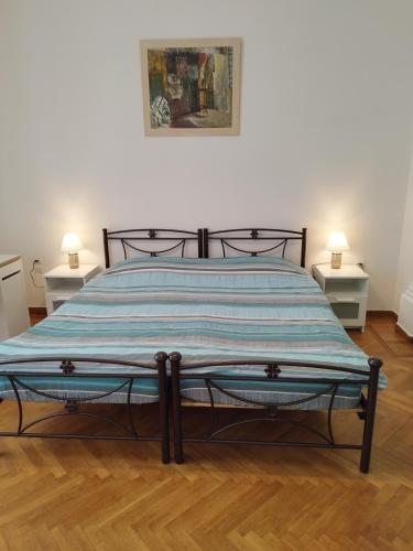 a bed in a room with two tables and two lamps at Комната pilika 4room with shared bath in Athens