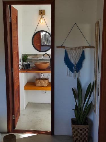 a door leading into a bathroom with a mirror at Chill Kite - Pousada Icaraí Kite Village in Icaraí
