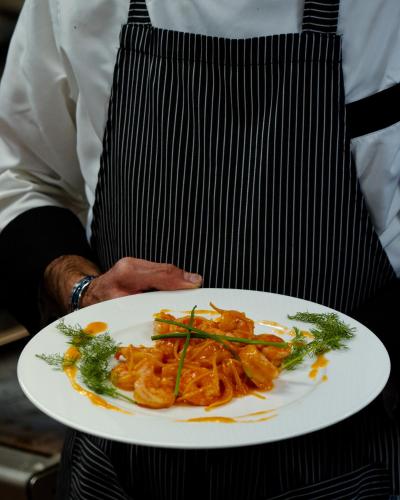 a chef is holding a plate of food at Hotel Ristorante Vecchia Riva in Varese
