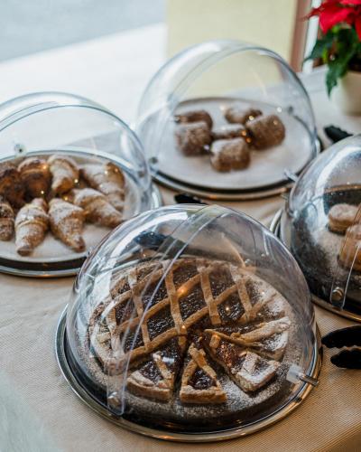 a table with four plates of different types of pastries at Hotel Ristorante Vecchia Riva in Varese