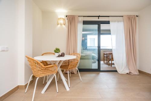 帕拉莫斯的住宿－Gran piso en Puerto deportivo Marina Palamós IDEAL FAMILIAS，一间配备有白色桌椅的用餐室
