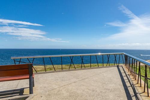 a bench sitting on a balcony looking at the ocean at Gran piso en Puerto deportivo Marina Palamós IDEAL FAMILIAS in Palamós