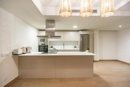 a kitchen with white counters and white cabinets at Gran piso en Puerto deportivo Marina Palamós IDEAL FAMILIAS in Palamós