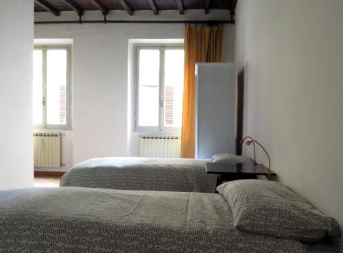 two beds in a bedroom with two windows at Macci Number Eight in Florence