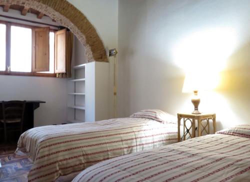 フィレンツェにあるMacci Number Eightのベッドルーム1室(ベッド2台、テーブルの上にランプ付)