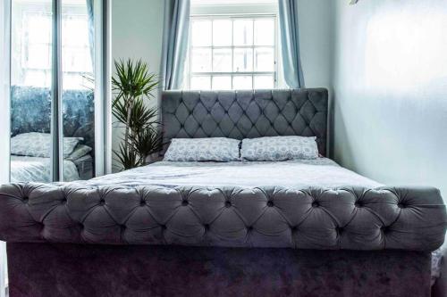 a bed in a bedroom with a leather headboard at Lovely flat in Crouch End in London