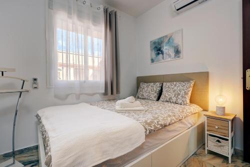 Schlafzimmer mit einem weißen Bett und einem Fenster in der Unterkunft Top Floor Fuengirola Park Apartment with Parking in Fuengirola