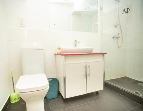 uma casa de banho com um WC branco e um lavatório. em Adrich Properties Gallery em Acra