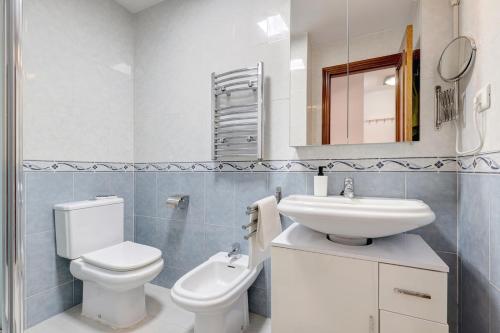 ein weißes Bad mit einem WC und einem Waschbecken in der Unterkunft Top Floor Fuengirola Park Apartment with Parking in Fuengirola