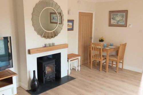 a living room with a fireplace and a mirror at Oakcroft in Sidmouth