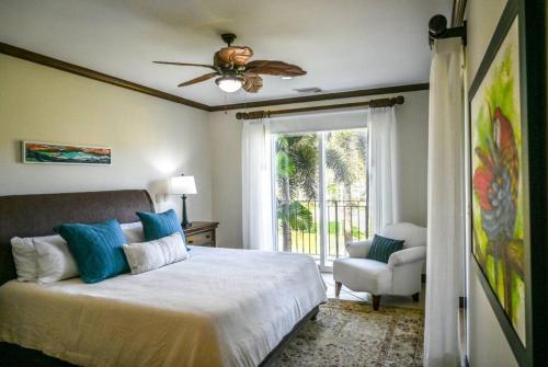 a bedroom with a bed with a ceiling fan and a chair at Bay Residence Los Suenos Resort & Marina in Herradura