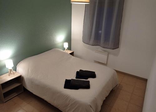 - une chambre avec un lit et 2 serviettes noires dans l'établissement Appartement proche Cité médiévale et centre ville - Parking privé, à Carcassonne