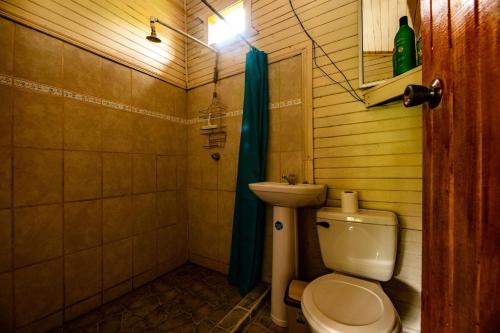 a bathroom with a toilet and a sink at Oso de Osa in Sierpe