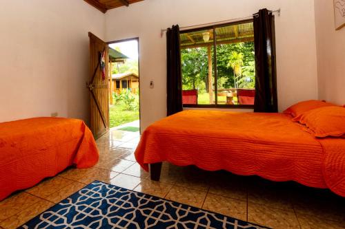 two beds sitting in a room with a window at Oso de Osa in Sierpe