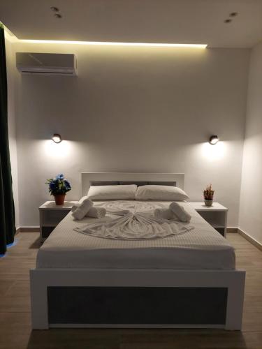 een slaapkamer met een groot wit bed en 2 verlichting bij Villa Vento in Ksamil