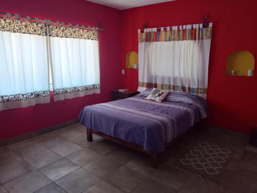 1 dormitorio con 1 cama con paredes y ventanas de color rojo en Descansó entre las montañas....., en Tepoztlán