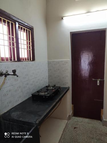 um quarto com um balcão preto e uma porta em Anve's Airport Nest em Visakhapatnam