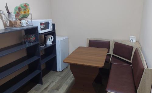 a kitchen with a wooden table and a small table and chairs at SKY&KTS Apartments in Boryspilʼ