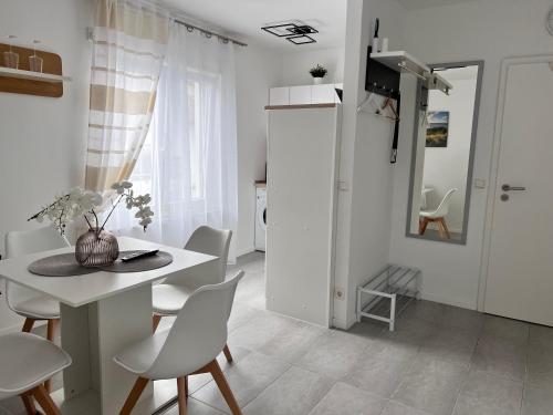 カールスルーエにあるPrime Host Style Apartmentのテーブルと椅子のある白いダイニングルーム