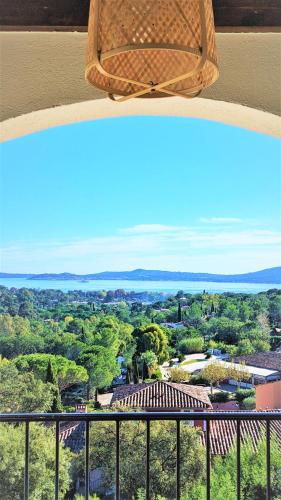 une vue d'une ville depuis un balcon dans l'établissement Vue Mer et clim Les Restanques Pivoines 1136, à Grimaud