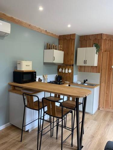 Il comprend une cuisine avec une table et des chaises en bois. dans l'établissement Le séchoir de l’Aerostier, à La Roque-Gageac