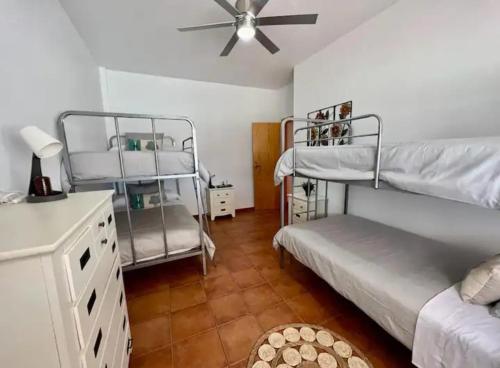 a room with two bunk beds and a ceiling fan at Villa vacacional Águilas in Águilas