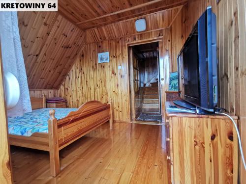 - une chambre avec un lit et une télévision dans l'établissement Duży Domek Nad Jeziorem - Kretowiny 64, à Kretowiny
