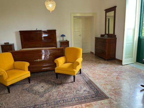 ein Wohnzimmer mit 2 Stühlen und einem Klavier in der Unterkunft casa vacanze zona vesuviana in Palma Campania