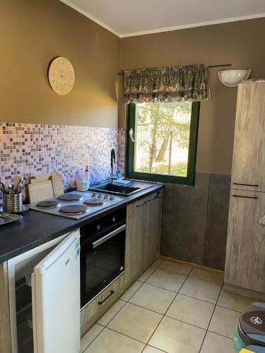 a kitchen with a stove and a sink and a window at Agroturystyka Oaza Ciszy i Spokoju in Międzychód
